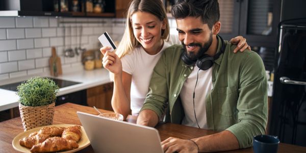 Happy couple shopping online with credit card.