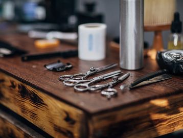 Barber tools neatly arranged on a wooden table.