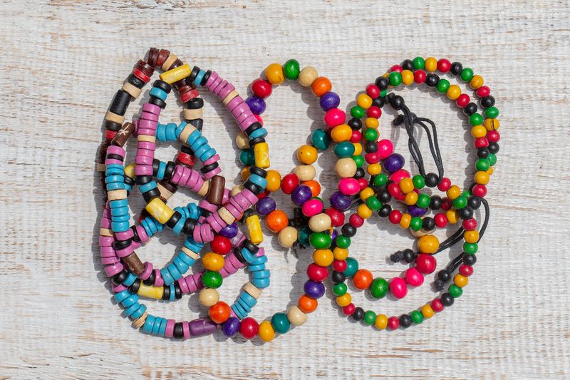 Colorful wooden beads bracelet on white wooden background for sale on local street market in Ubud, island Bali, Indonesia, close up, top view