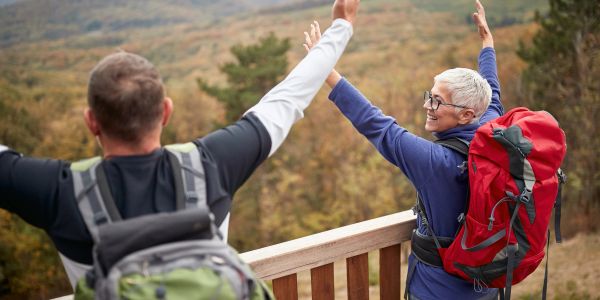 Two hikers celebrating outdoors with backpacks.