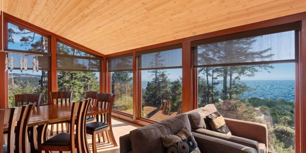 Cozy sunroom with wooden ceiling and ocean view.