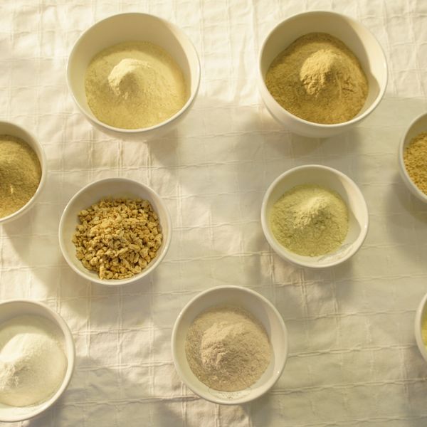 Various powders and granules in bowls on a checkered cloth.
