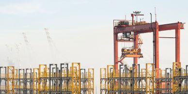 Large industrial cranes and metal frameworks at a construction site.