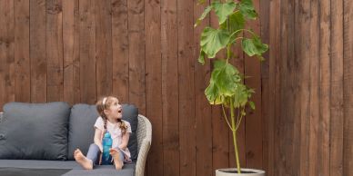Surprised girl looking at a tall sunflower.