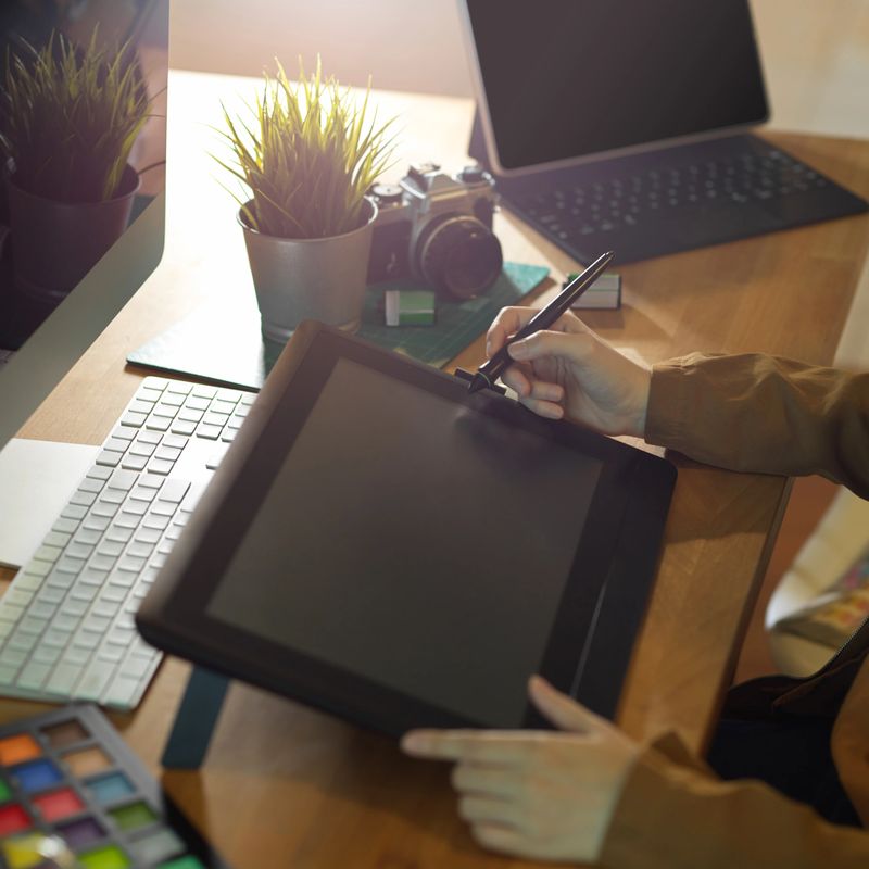 Cropped shot of female graphic designer working on drawing tablet on computer desk
