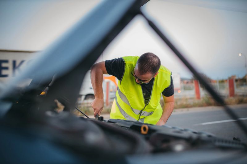 Man repairing car on road