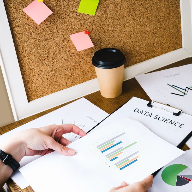 Business woman conducts financial analytics of available data using graphs and tables. Data science concept. Workplace
