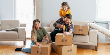 Family unpacking boxes happily at home.