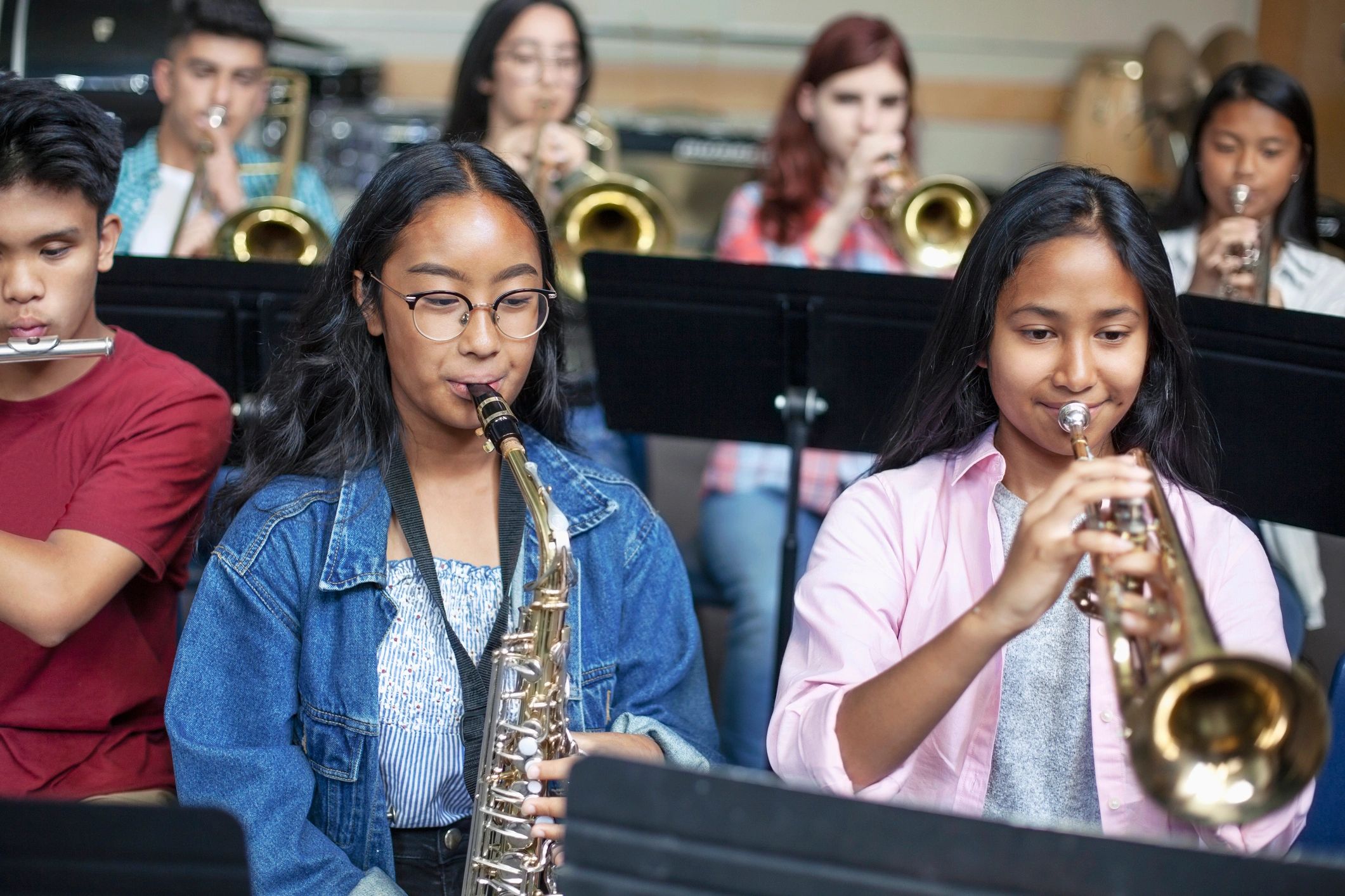 Group of young musicians playing wind instruments in a band.