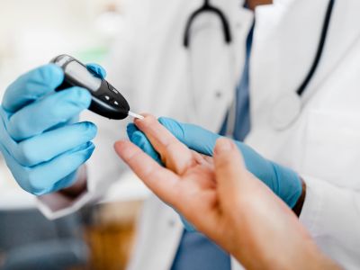 Doctor checking blood sugar levels with glucometer.