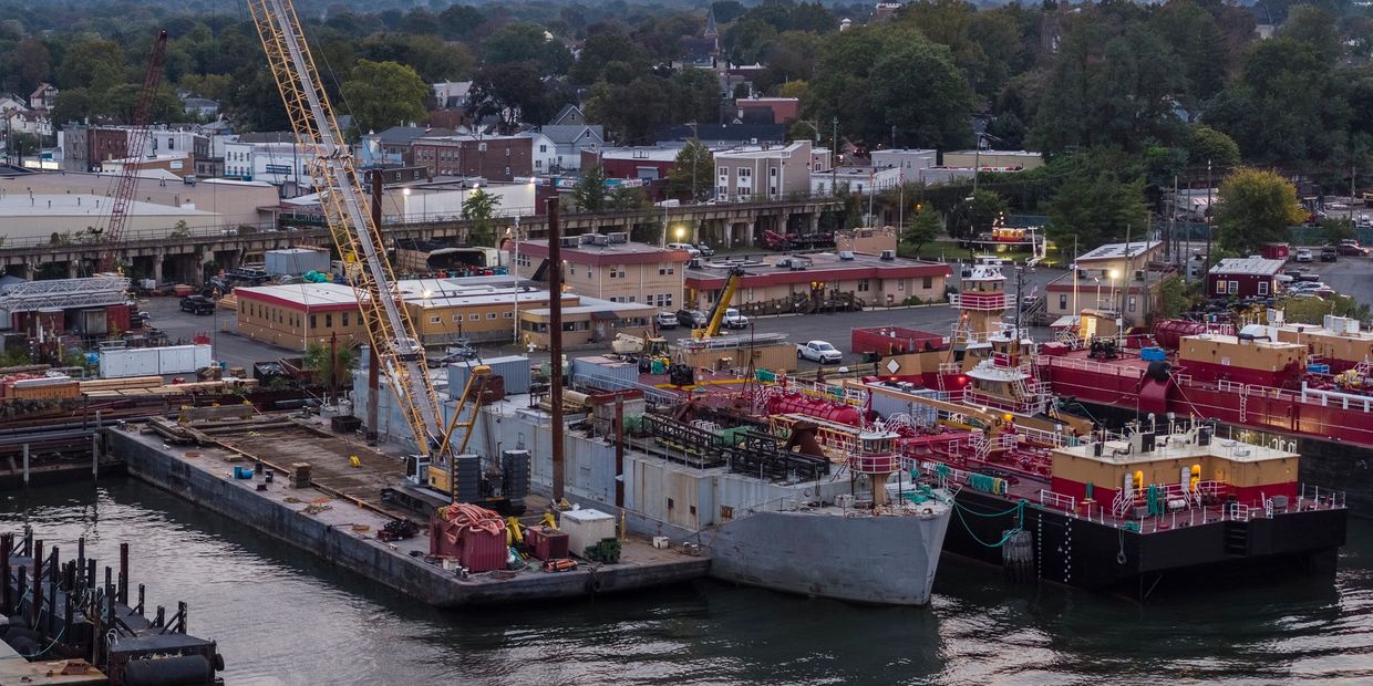 Industrial dockyard with cranes and ships at sunset.