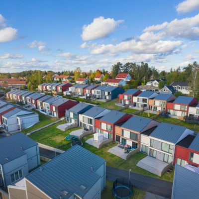 Aerial view of a suburban neighborhood with modern townhouses and clear skies.