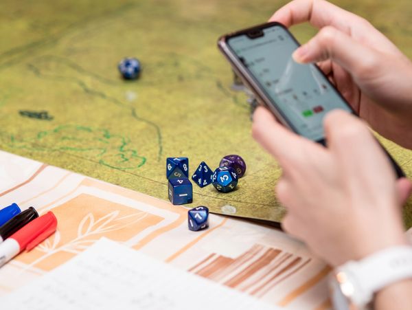 Person holding phone during a tabletop RPG game.