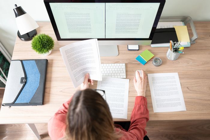 Person working at a tidy desk with Spanish translation documents and a computer.