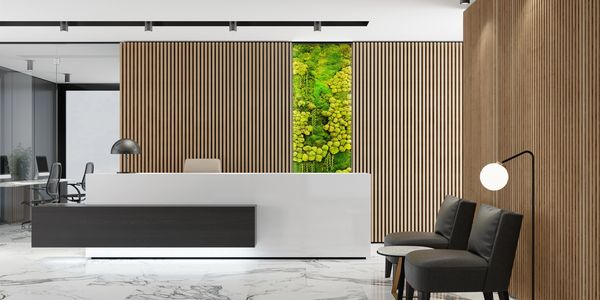 Modern office reception area with wooden paneling and green moss wall art.