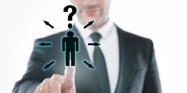 Businessman pointing at a human icon with question mark and arrows.