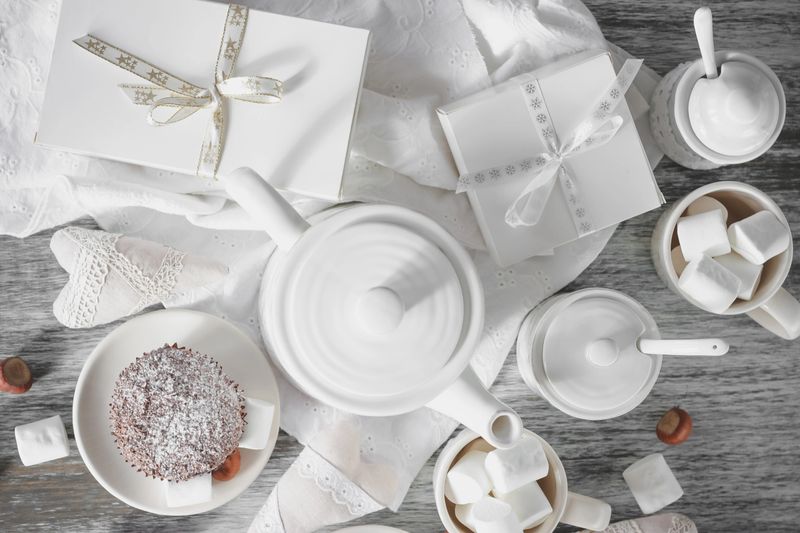 Teapot, cupcakes and different decorations, top view