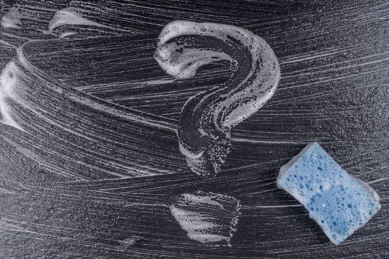 Question mark made from soap foam on a black background. Abstract foam texture on black background. Soap foam bubbles abstract dark background , top view