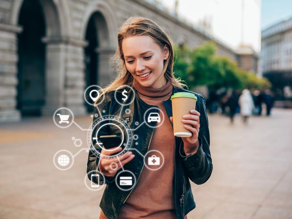 Woman using mobile payment app outdoors with digital icons.