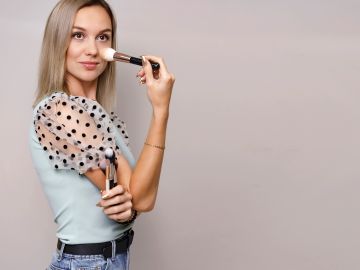 Woman applying makeup with a brush.