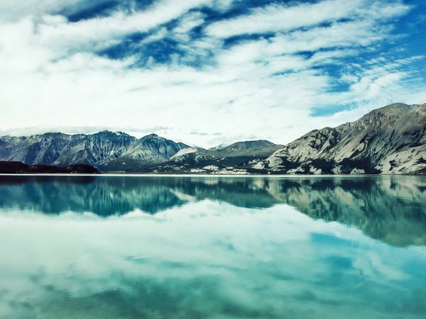 A serene landscape featuring mountains, a lake, and a clear blue sky, ideal for relaxation and nature appreciation.