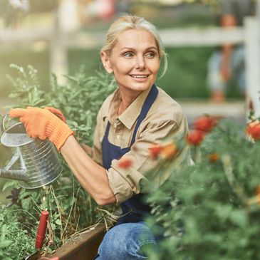 Woman in garden watering flowers