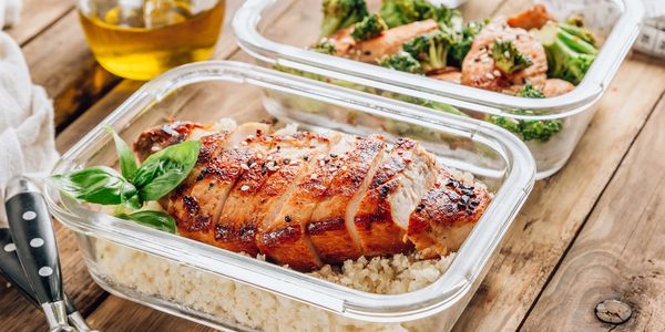 Grilled chicken meal prep with rice and broccoli in glass containers.