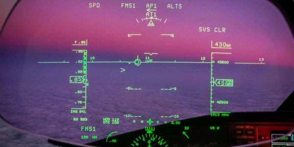 Futuristic cockpit HUD showing flight data against a purple sky.