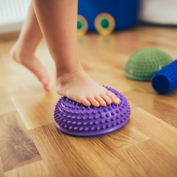 Child's foot on a purple spiky balance pod.