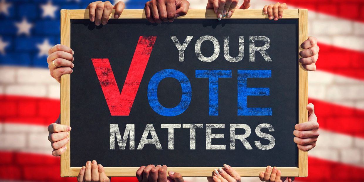 Hands holding a sign saying "Your Vote Matters" with an American flag background.