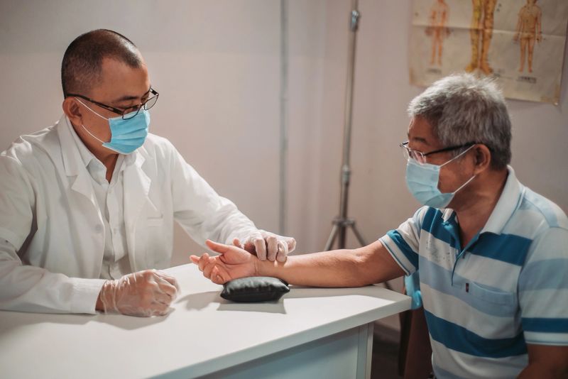chinese medicine doctor measuring pulse with hand for his patient