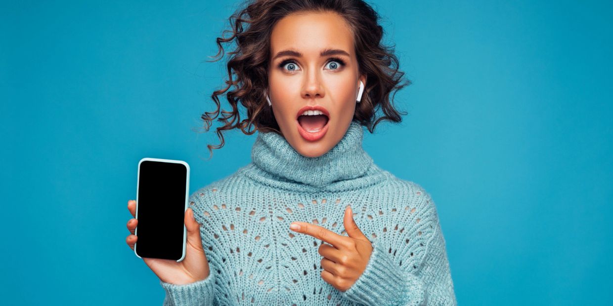 Woman excitedly showing blank phone screen.