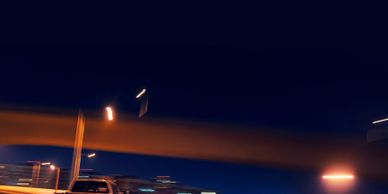 White truck driving on a curved highway at night with motion blur.