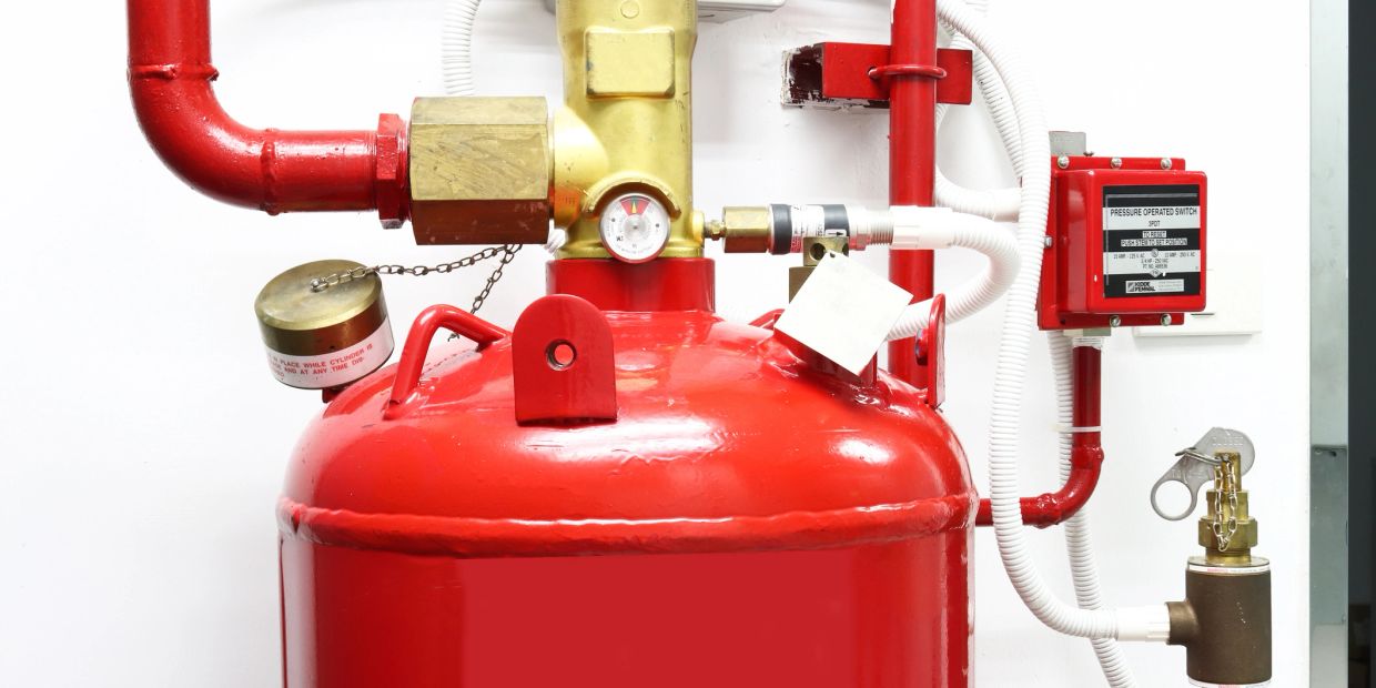 Close-up of a red fire suppression system tank.