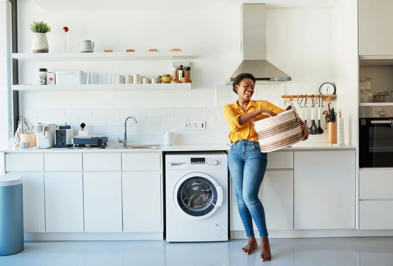 Shot of a young woman doing her laundry at home