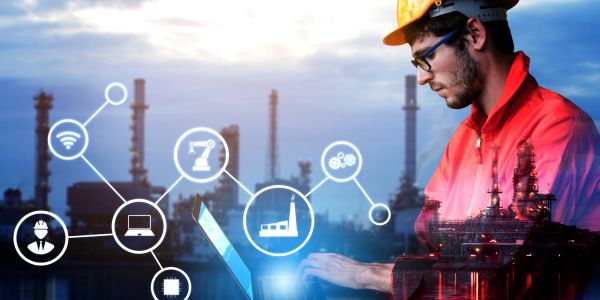 Engineer using laptop with industrial icons and refinery background.