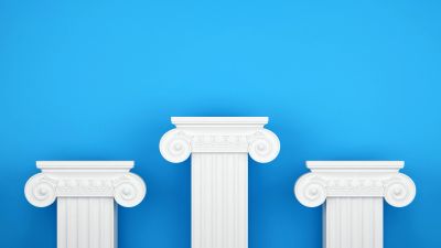 Three white Ionic columns against a blue background.