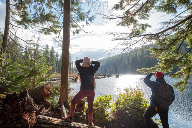 Multi-ethnic daughter and Caucasian father hiking at Buntzen Lake, a regional public park near Anmore, British Columbia, Canada
