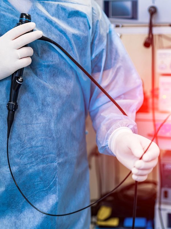 Doctor holding an endoscope in a medical setting.