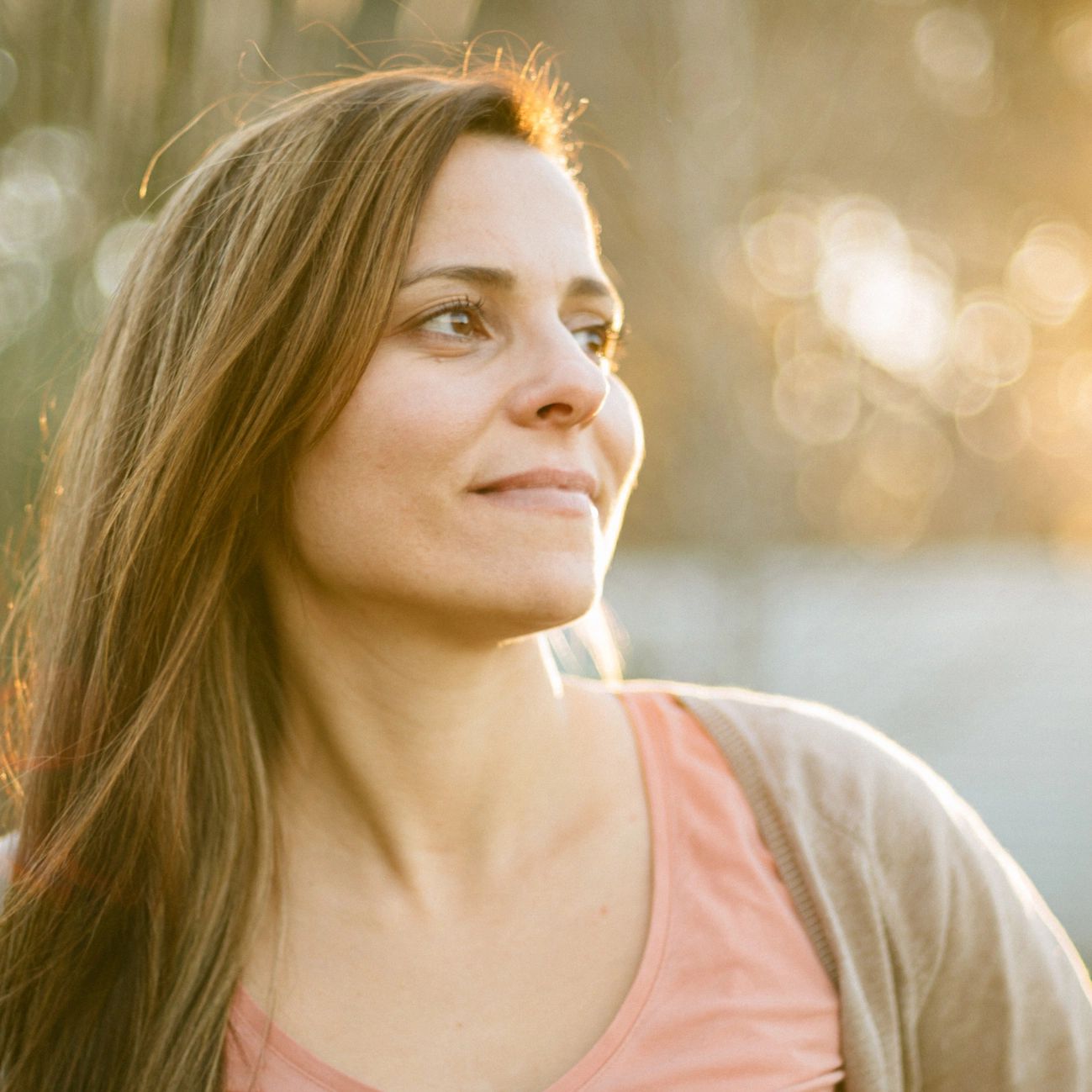 Woman smiling softly in warm morning sunlight