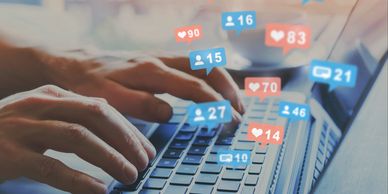 Hands typing on a laptop with social media notifications floating around.