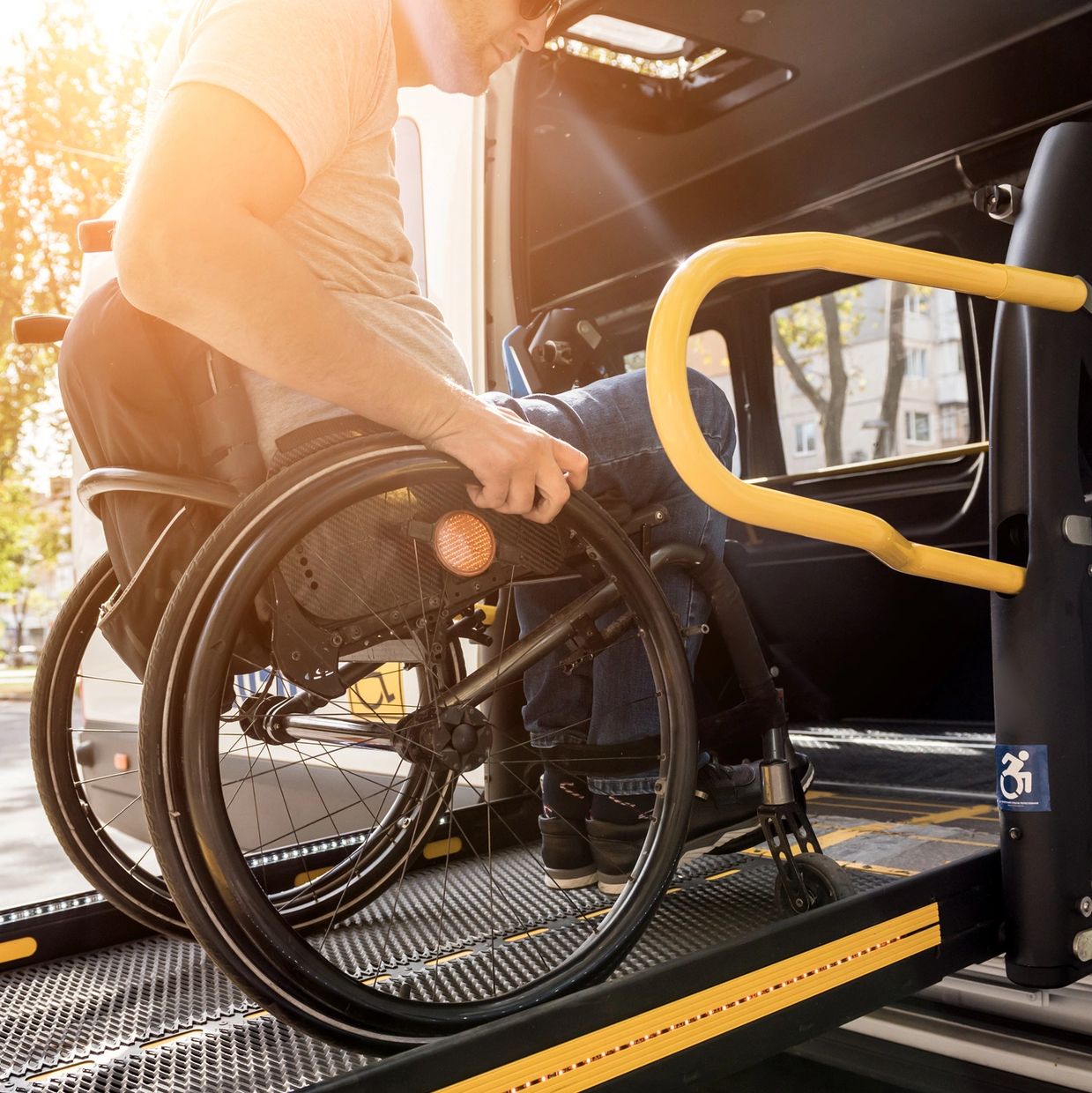 Man in wheelchair using ramp to enter accessible van.