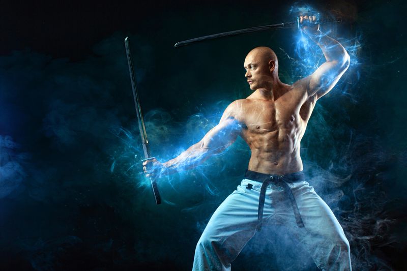 Karate fighter on black background with smoke. Shirtless man samurai with Japanese sword. Fit man sportsmen bodybuilder physique and athlete. Men's sport motivation
