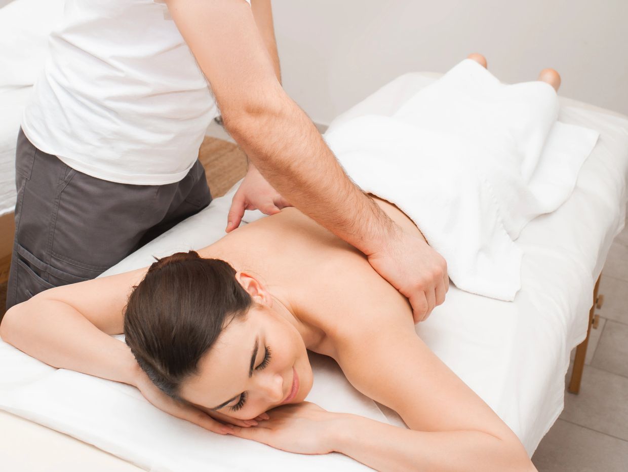 A woman enjoying a relaxing back massage at a spa.