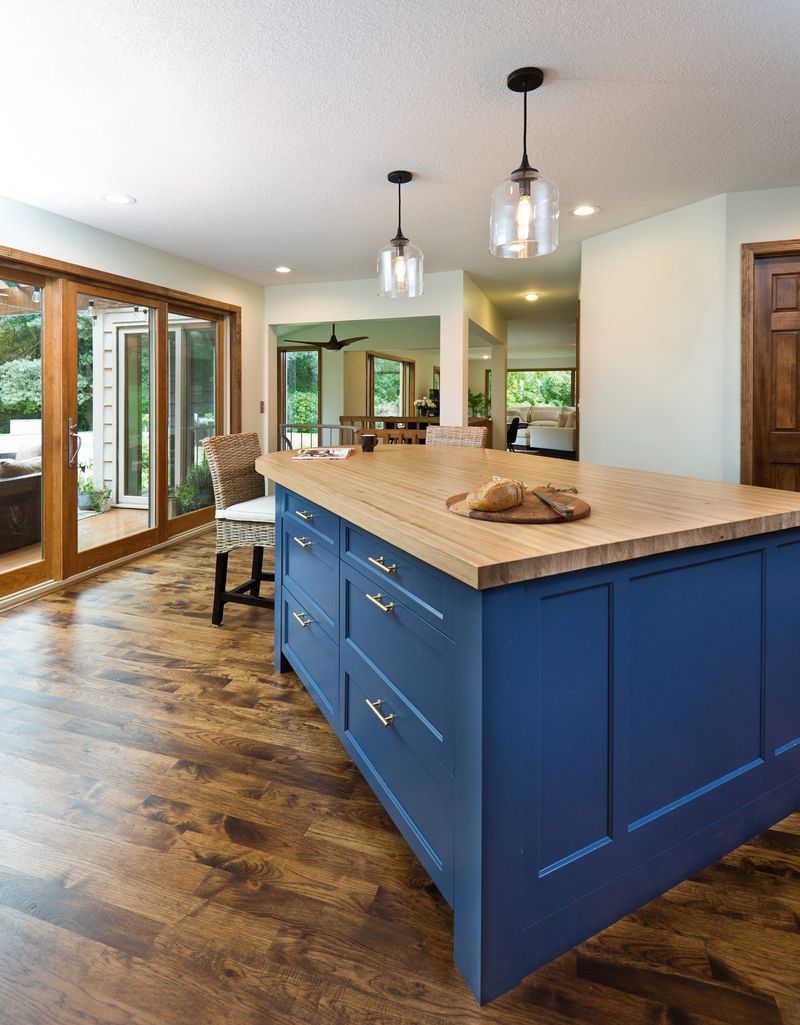 A contemporary open concept kitchen renovation remodeling featuring a center island, hardwood floor and quartz counter.