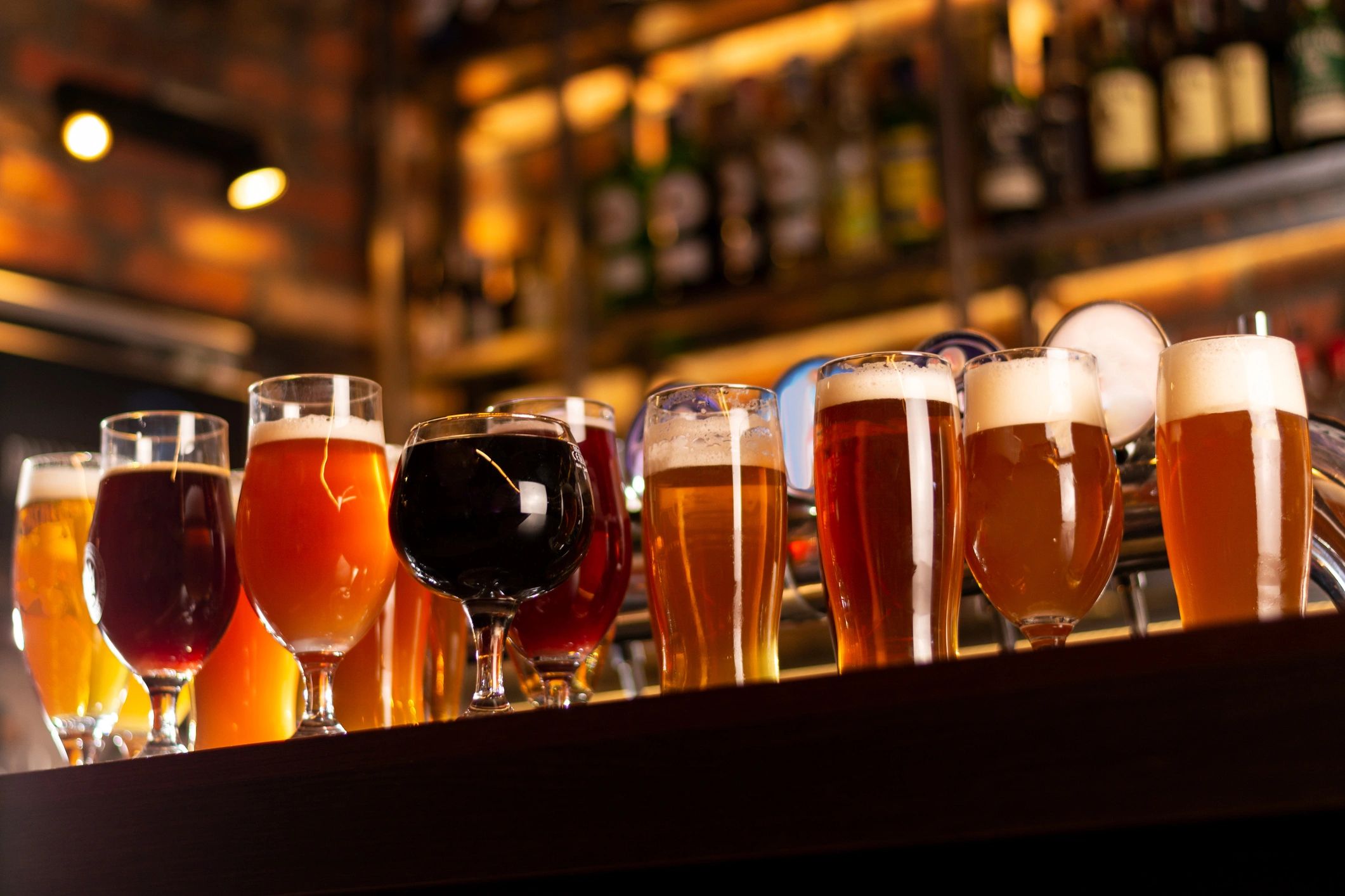 Variety of beers on a bar counter.