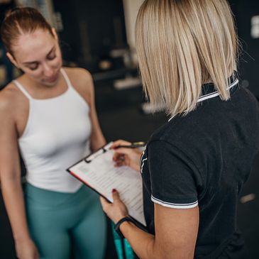 Dos mujeres conversando, una con clipboard.