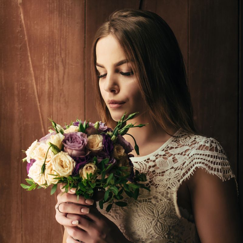 girl holding flowers in hands, young beautiful bride in white dress holding wedding bouquet, bouquet of bride from rose cream spray, rose bush, rose purple Memory Lane, violet eustoma, eucalyptus