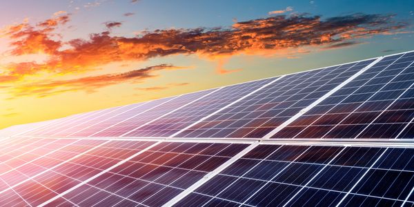 Solar panels reflecting the vibrant colors of a sunset sky.