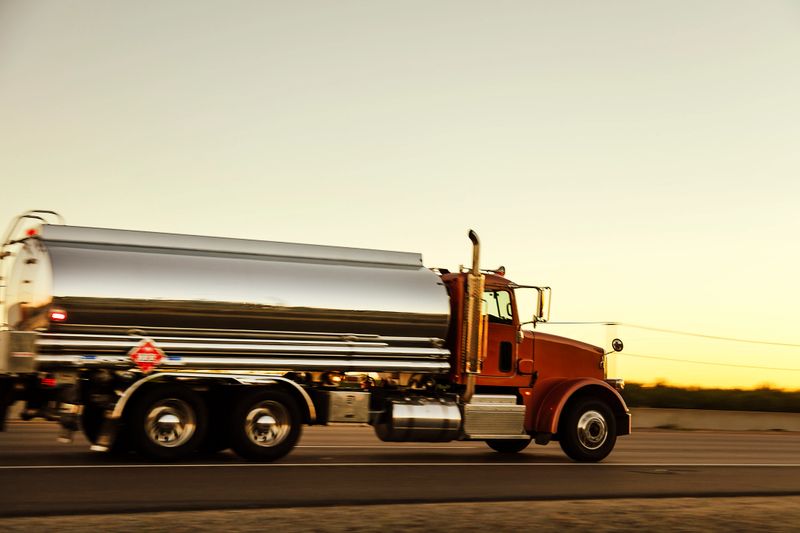 Fast and powerful heavy-lift modern tanker truck speeding on highway in sunset light, blurred motion, western USA, Nevada.